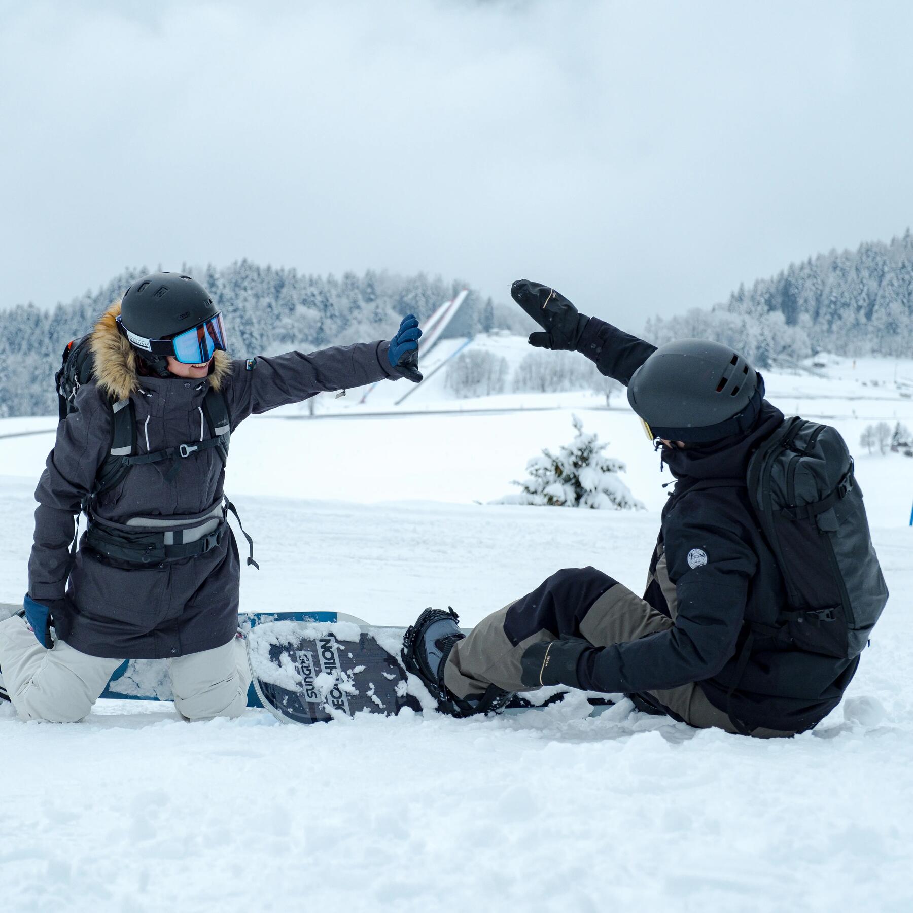 Femme et homme en snowboard qui se tapent la main
