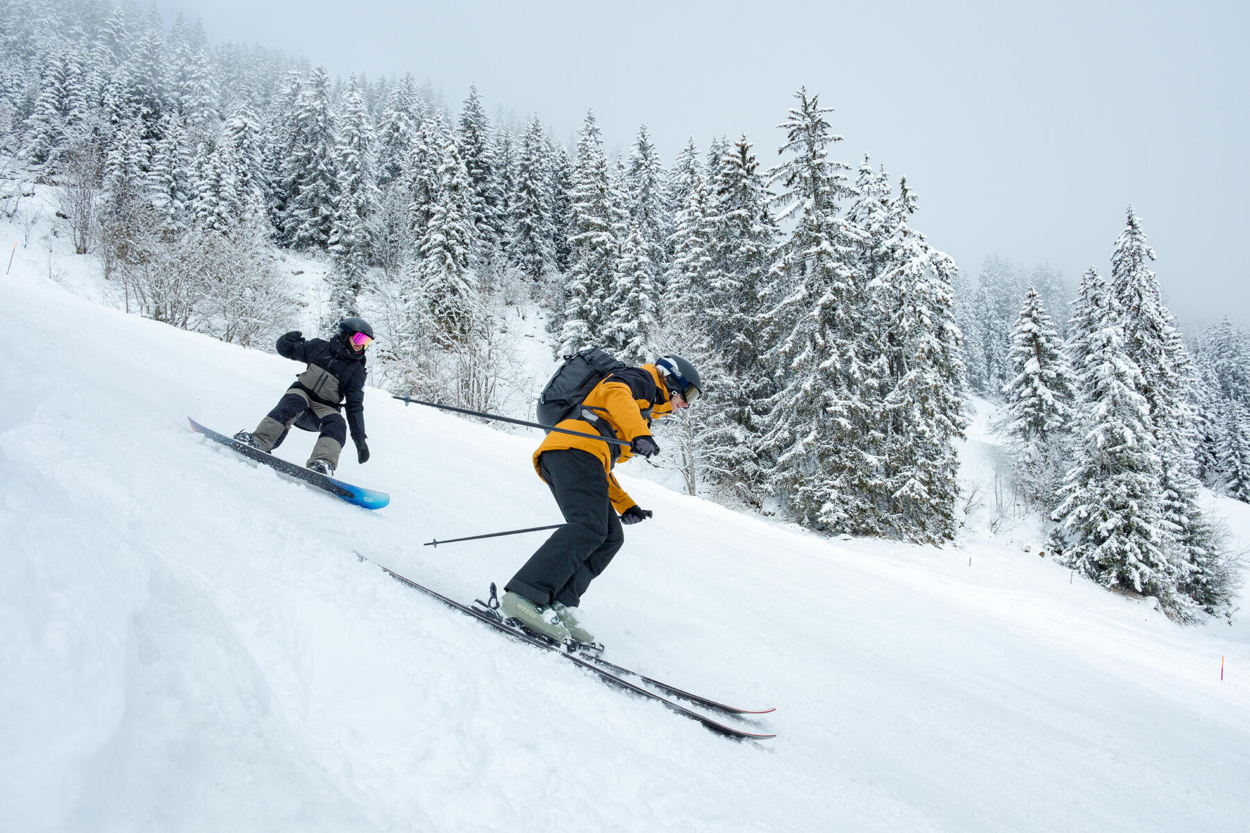 Narciarz i snowboardzista zjeżdżający na stoku