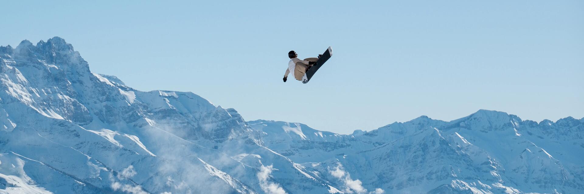 Mężczyzna trenujący snowboarding w snowparku