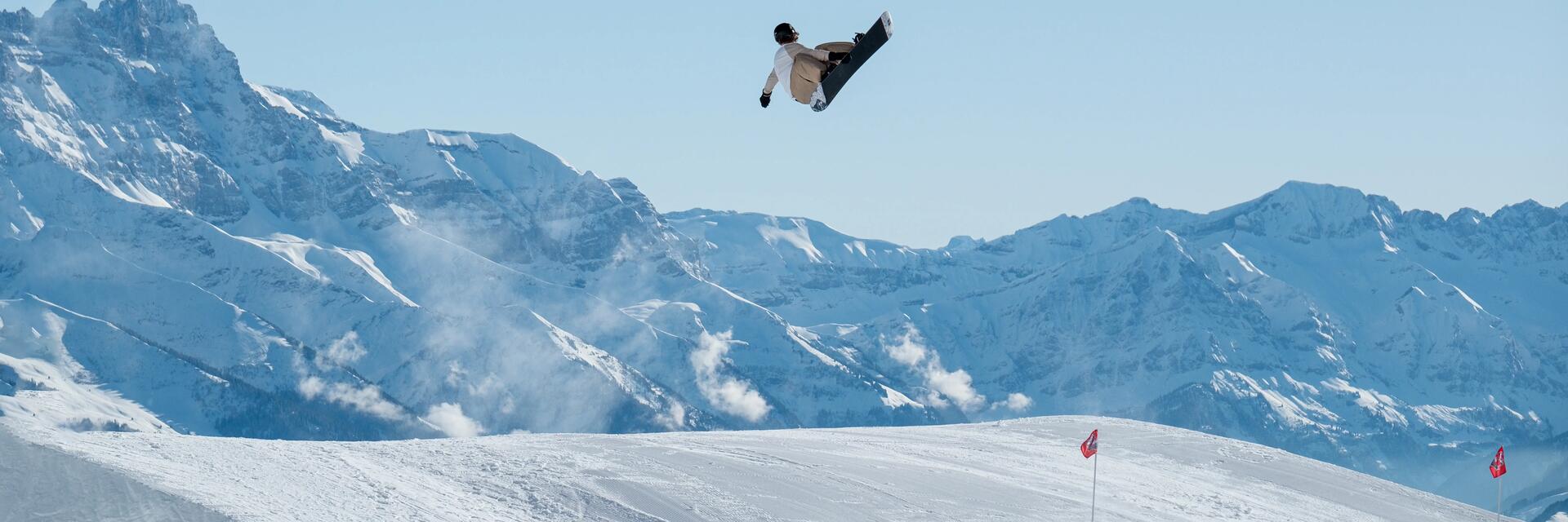 Mężczyzna trenujący snowboard na stoku w snowparku