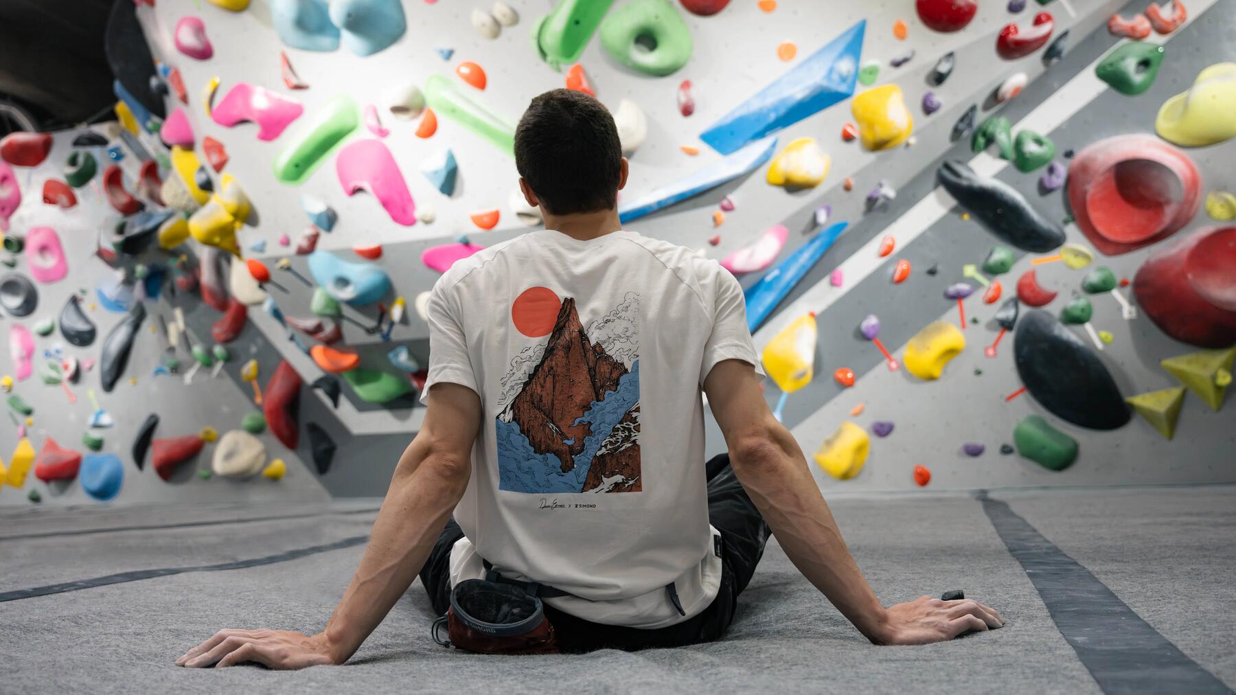 Mann bouldert vor einer Boulderwand, Bouldern als einfacher Einstieg für das Sportklettern