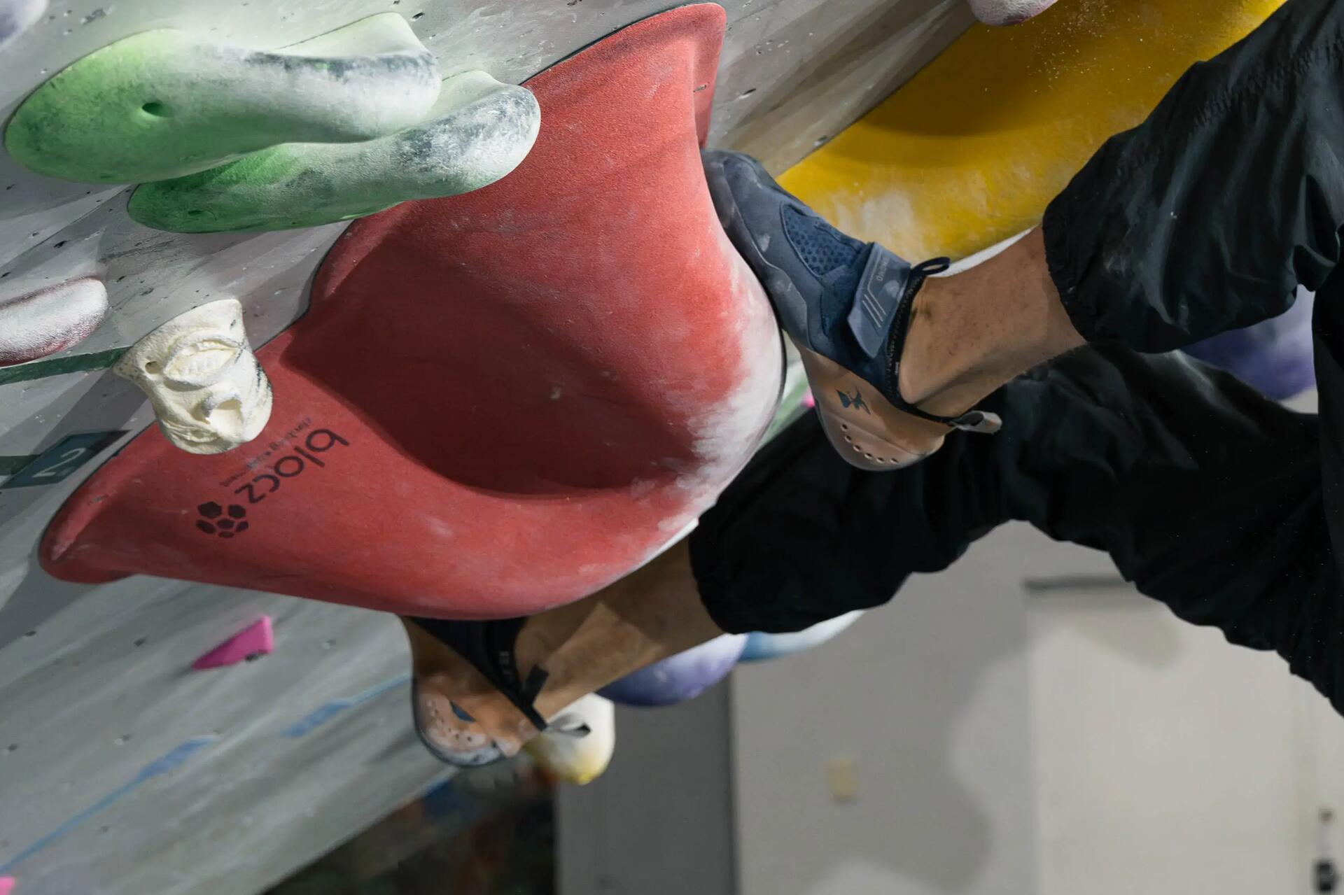 Iemand op een klimmuur met klimschoenen aan