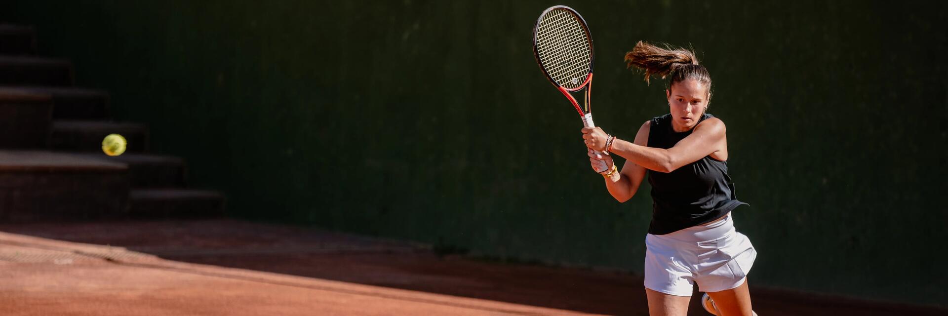 Frau spielt mit der passenden Tennisbekleidung für Damen