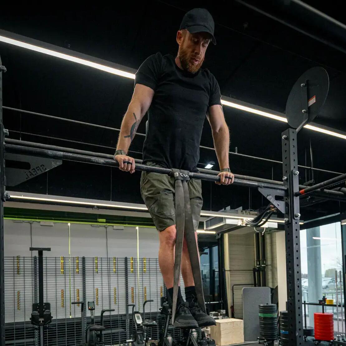Hombre haciendo ejercicio Muscle up con gomas
