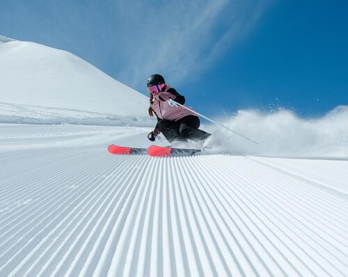 How to choose a pair of Decathlon ski trousers Girl in pink jacket carving on ski slopes