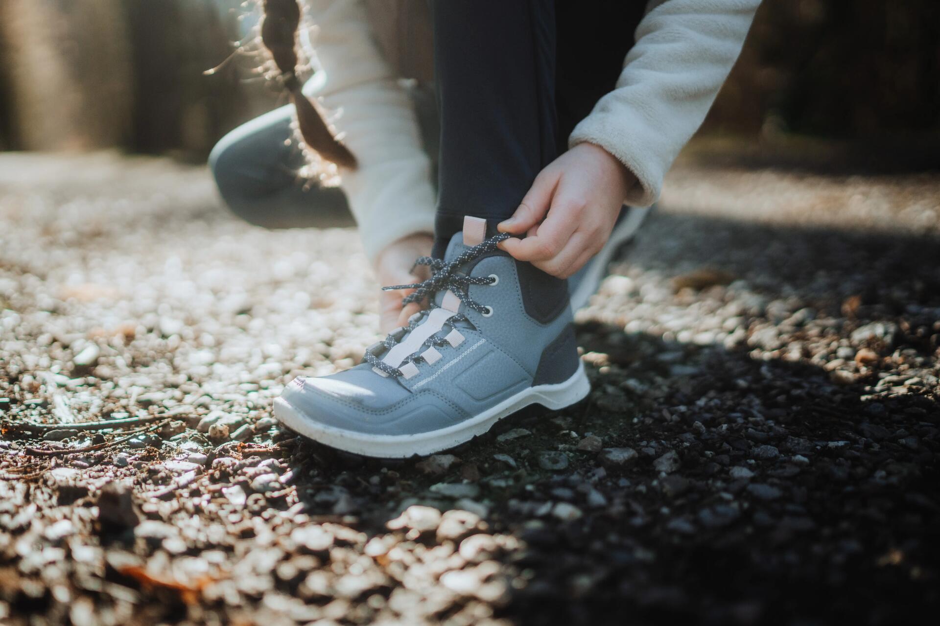 Kobieta zawiązująca sznurówki w butach trekkingowych
