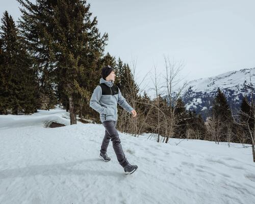 Mężczyzna idący po śniegu podziwiający Tatry polskie