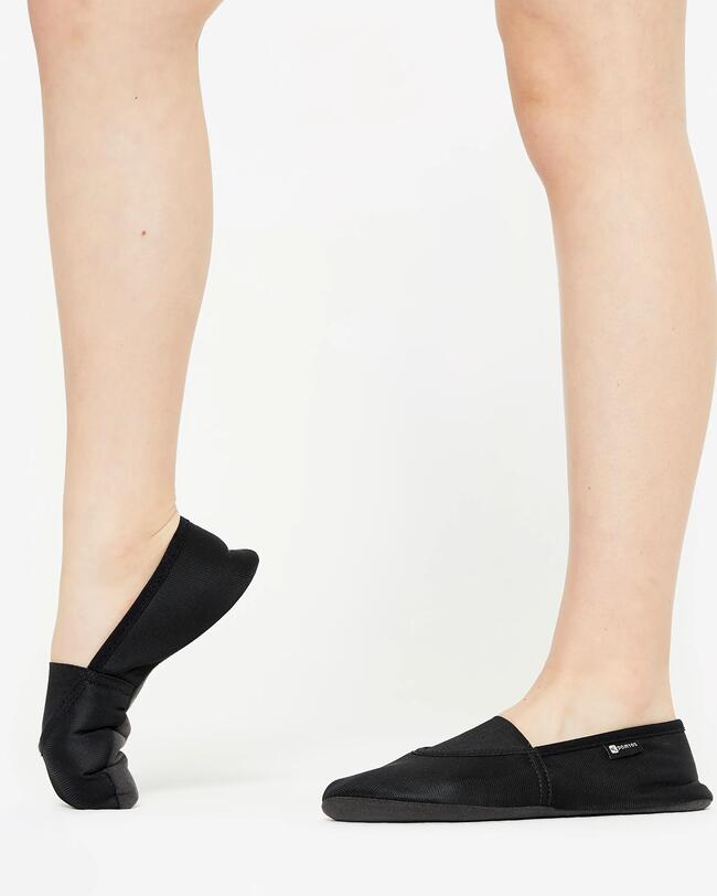Eine Frau trägt schwarze Gymnastikschuhe.