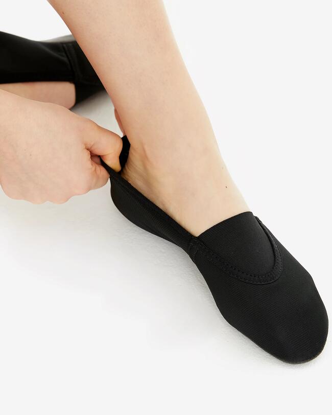 Eine Frau trägt schwarze Gymnastikschuhe.
