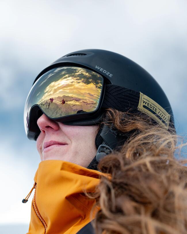 Frau schaut in den Himmel mit der Skibrille 