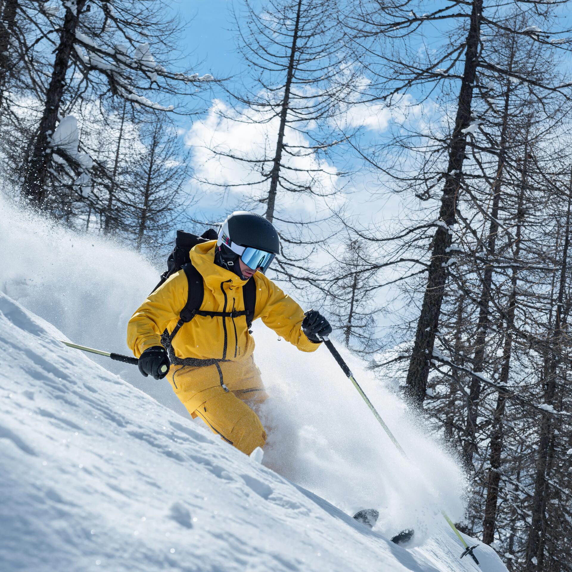 Man freeride skiing in a yellow Decathlon skiing outfit