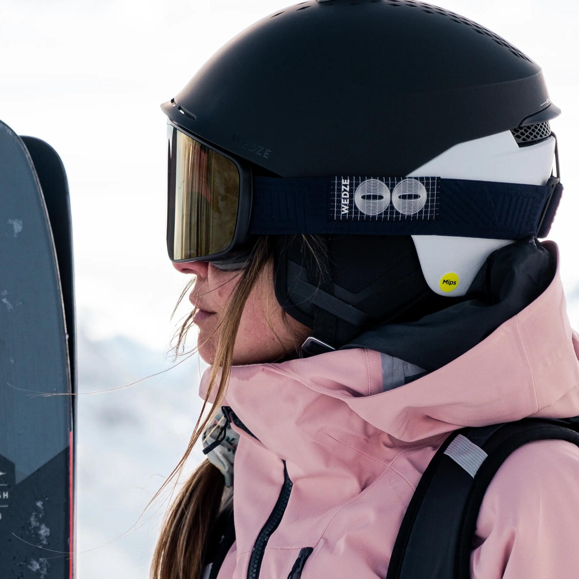 Fille à ski en montagne avec casque et veste de ski rose decathlon