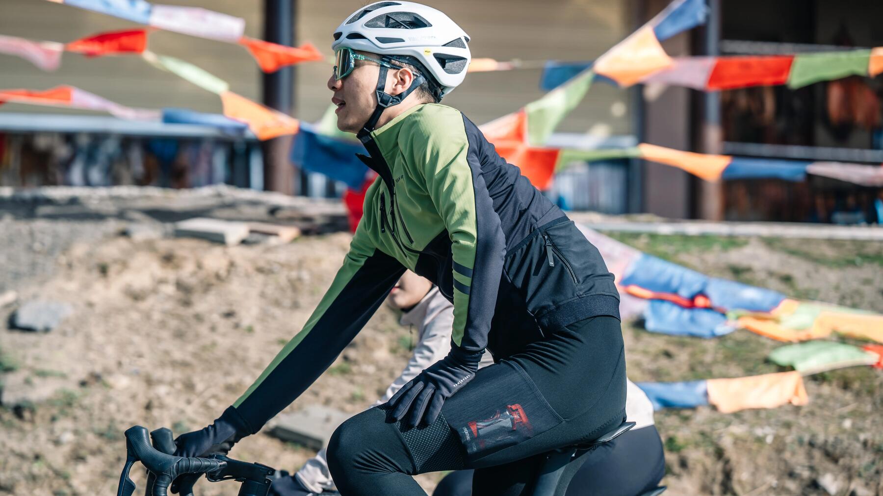 Kolarz w odzieży rowerowej w kasku i w okularach na rowerze