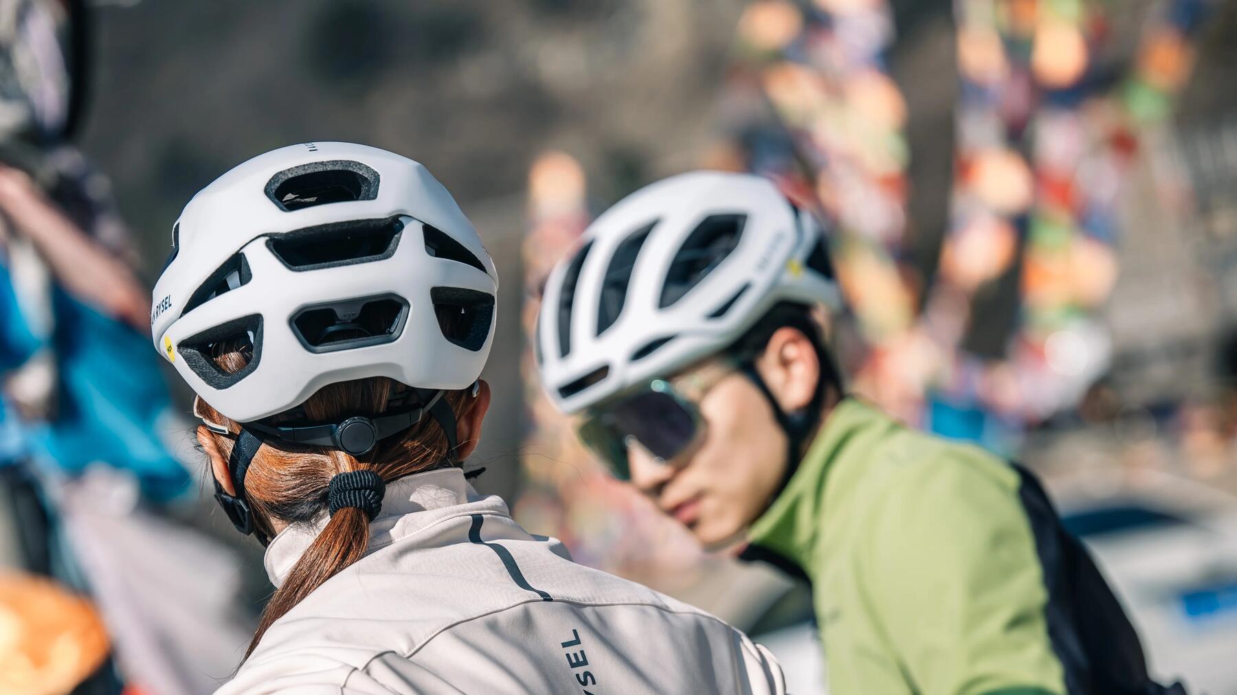 Triathloniści w kaskach rowerowych szykujący się do startu podczas zawodów triathlonowych na rowerach 