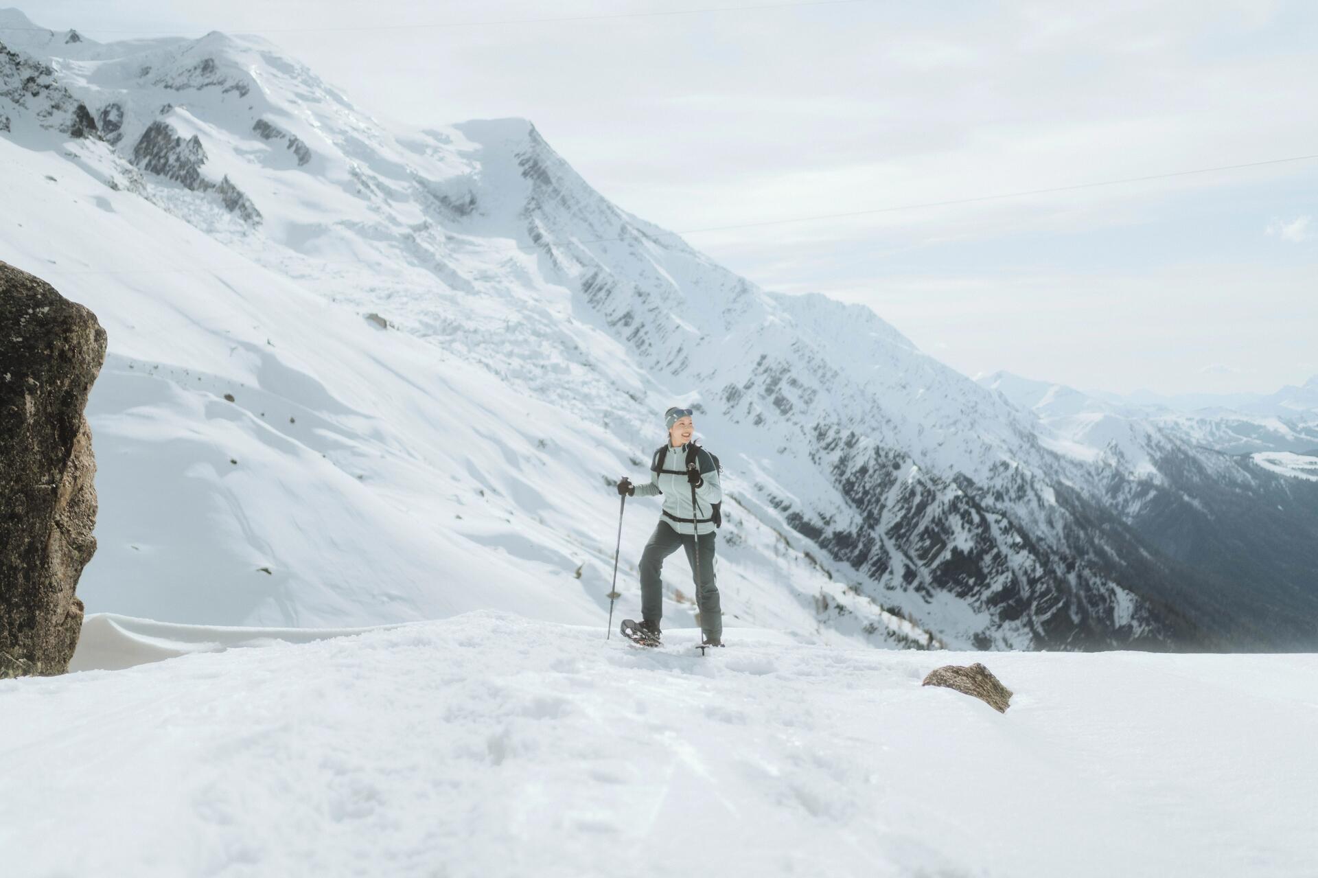 Une  femmes en raquette à neige contemplant la nature