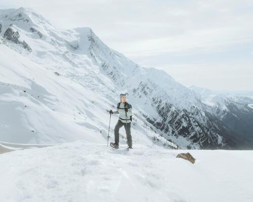 Une  femmes en raquette à neige contemplant la nature