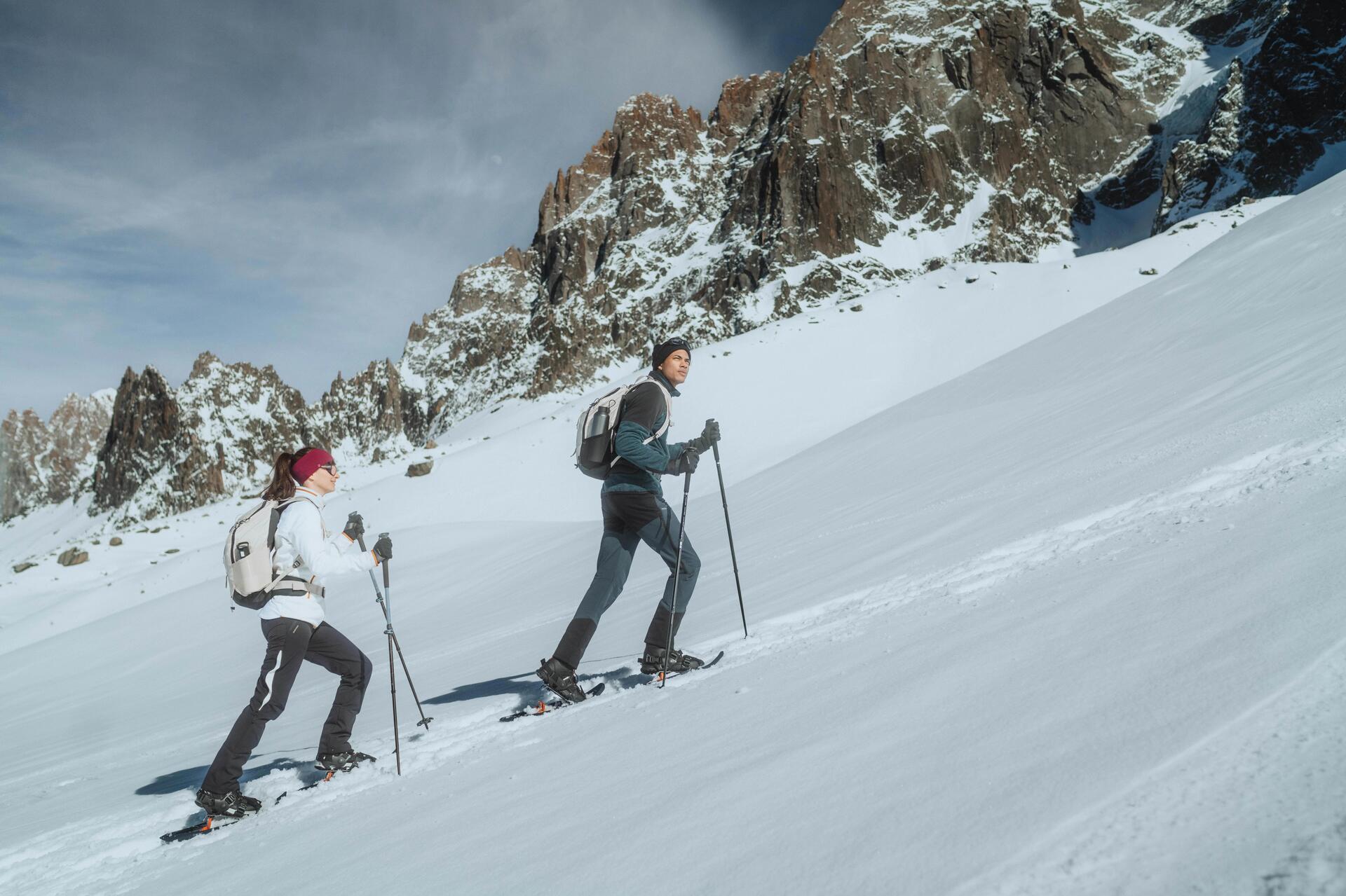 Amis qui marchent en raquette à neige dans la montagne