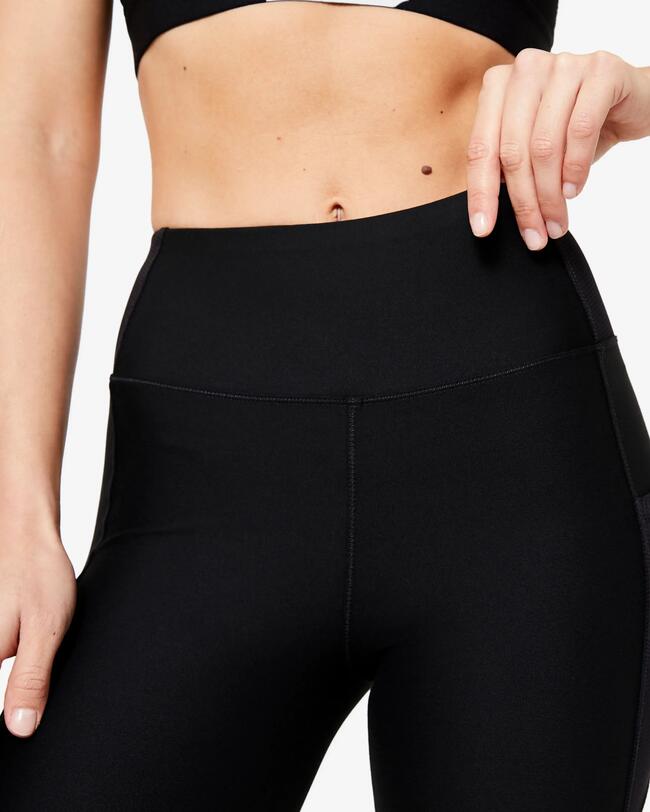 Frau macht Fitnessübungen. Sie befindet sich gerade in einem Sprung.