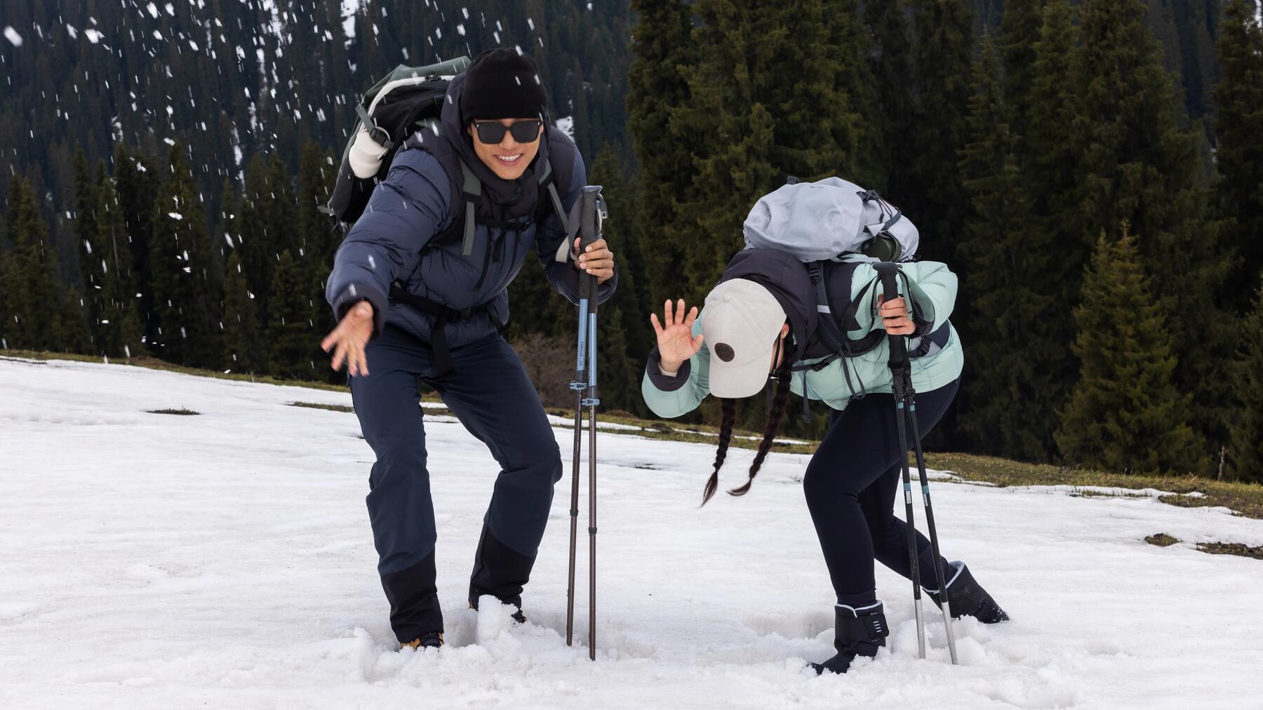Zwei Personen haben mit Trekkingstöcken Spaß im Schnee
