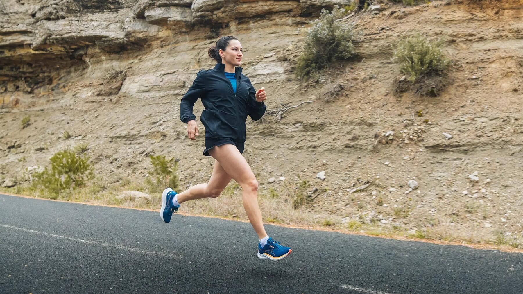 Vrouw lekker aan het hardlopen over de weg in de bergen