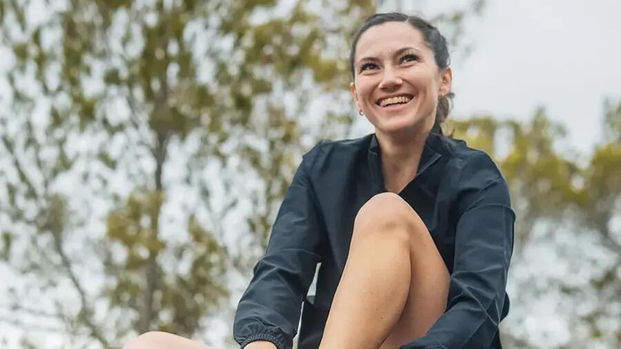 Eine Läuferin absolviert ihre Dehnroutine im Park vor dem Start ihrer Jogging-Runde!