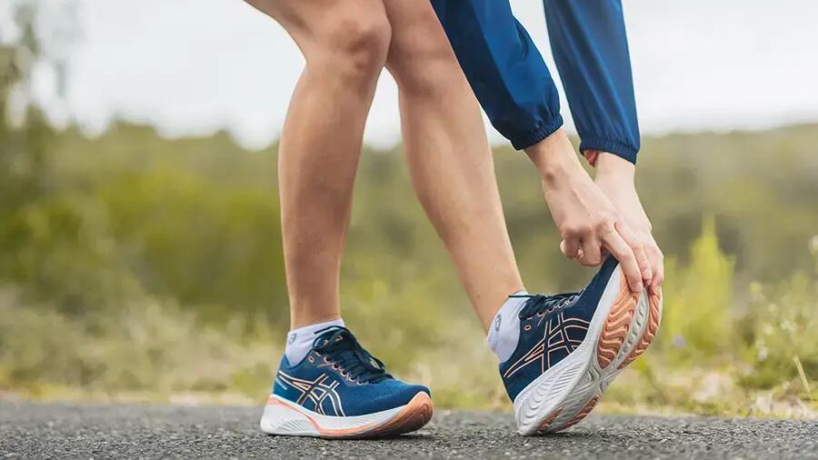 Dehnen vor dem Joggen: Klassische Wadendehnung an einer Wand zur Vorbereitung der Achillessehne!