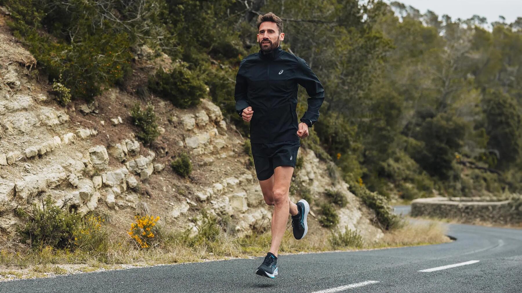 Man aan het hardlopen over de weg in de bergen