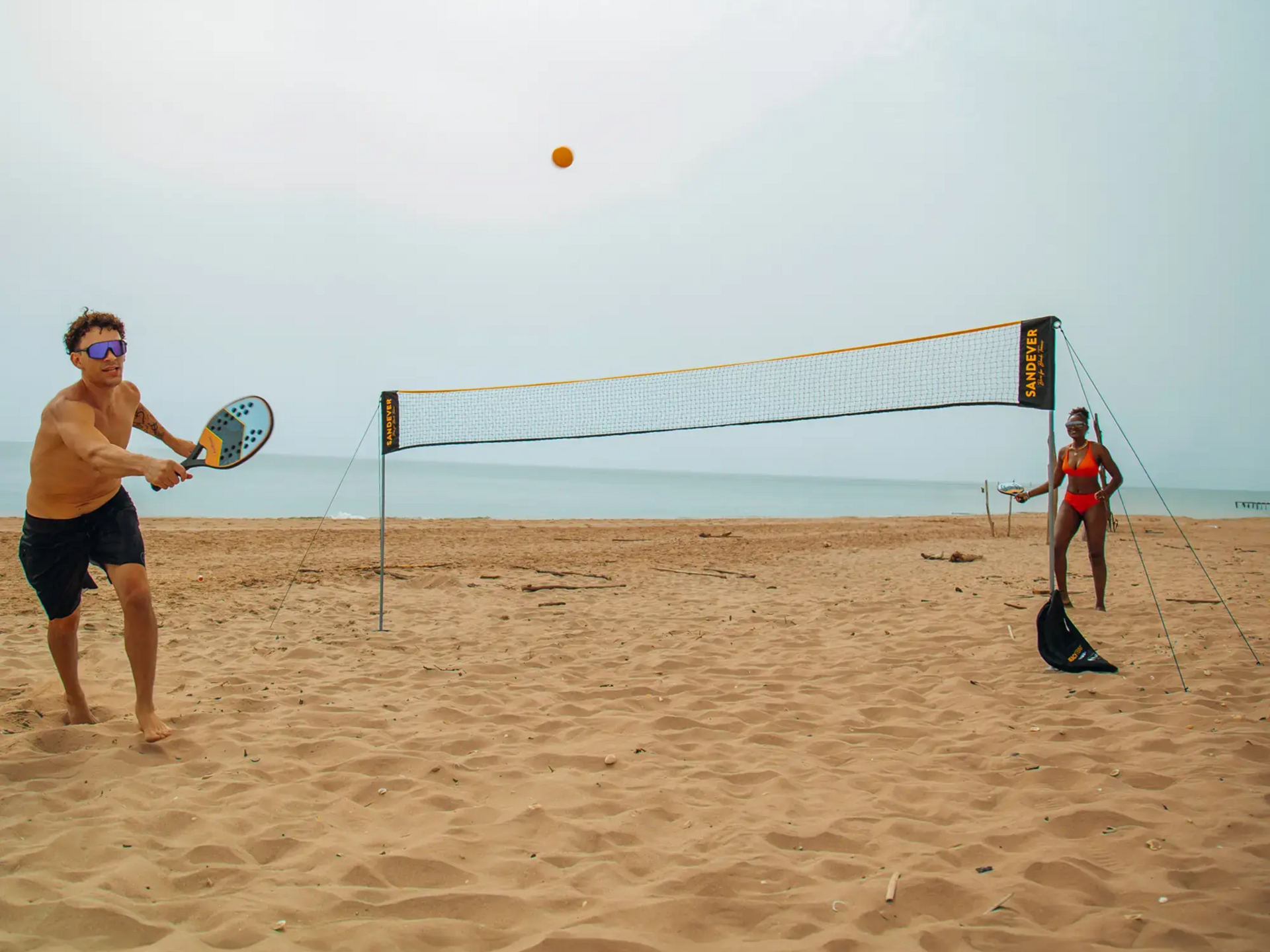 Kobieta i mężczyzna grający w tenisa na plaży