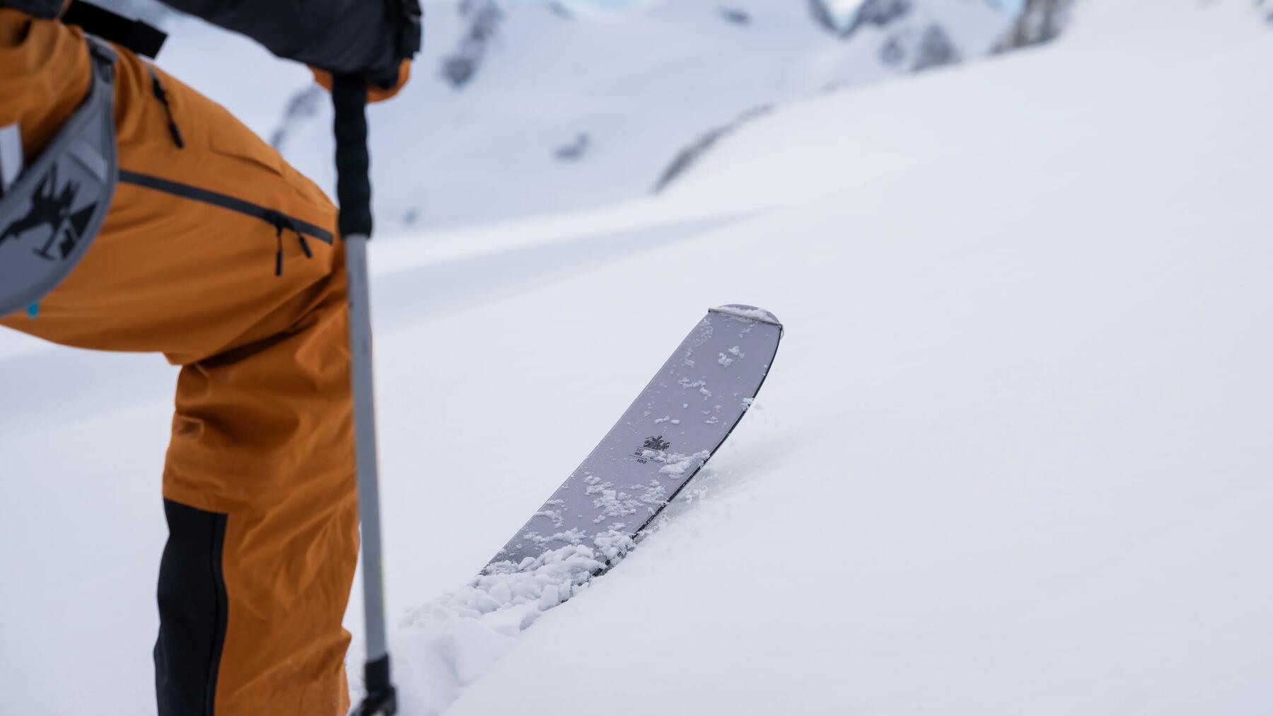 Skifahrer zieht erste Spuren in den tiefen Pulverschnee bei der Abfahrt
