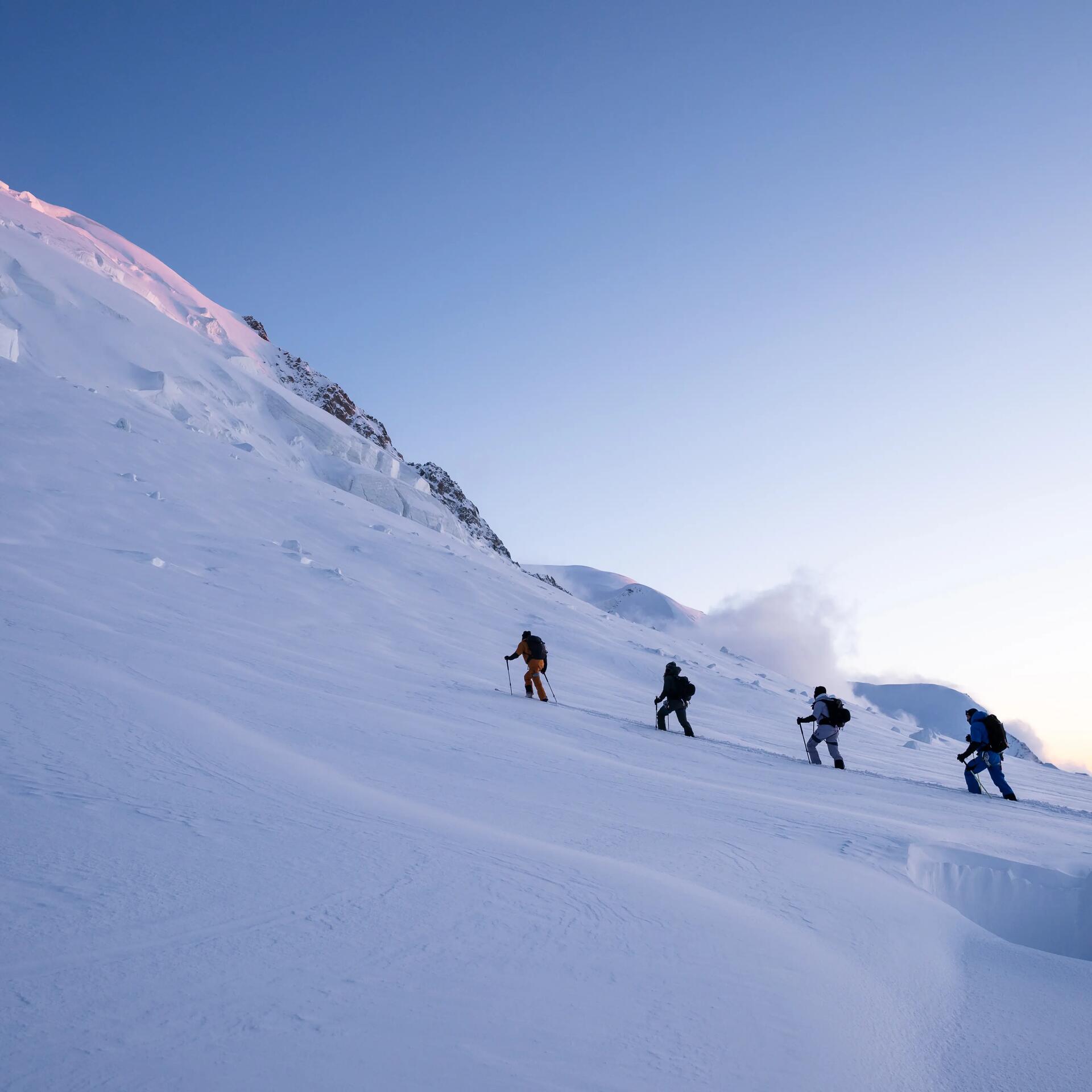 Des skieurs en ski de randonnée en train de monter au lever du soleil decathlon