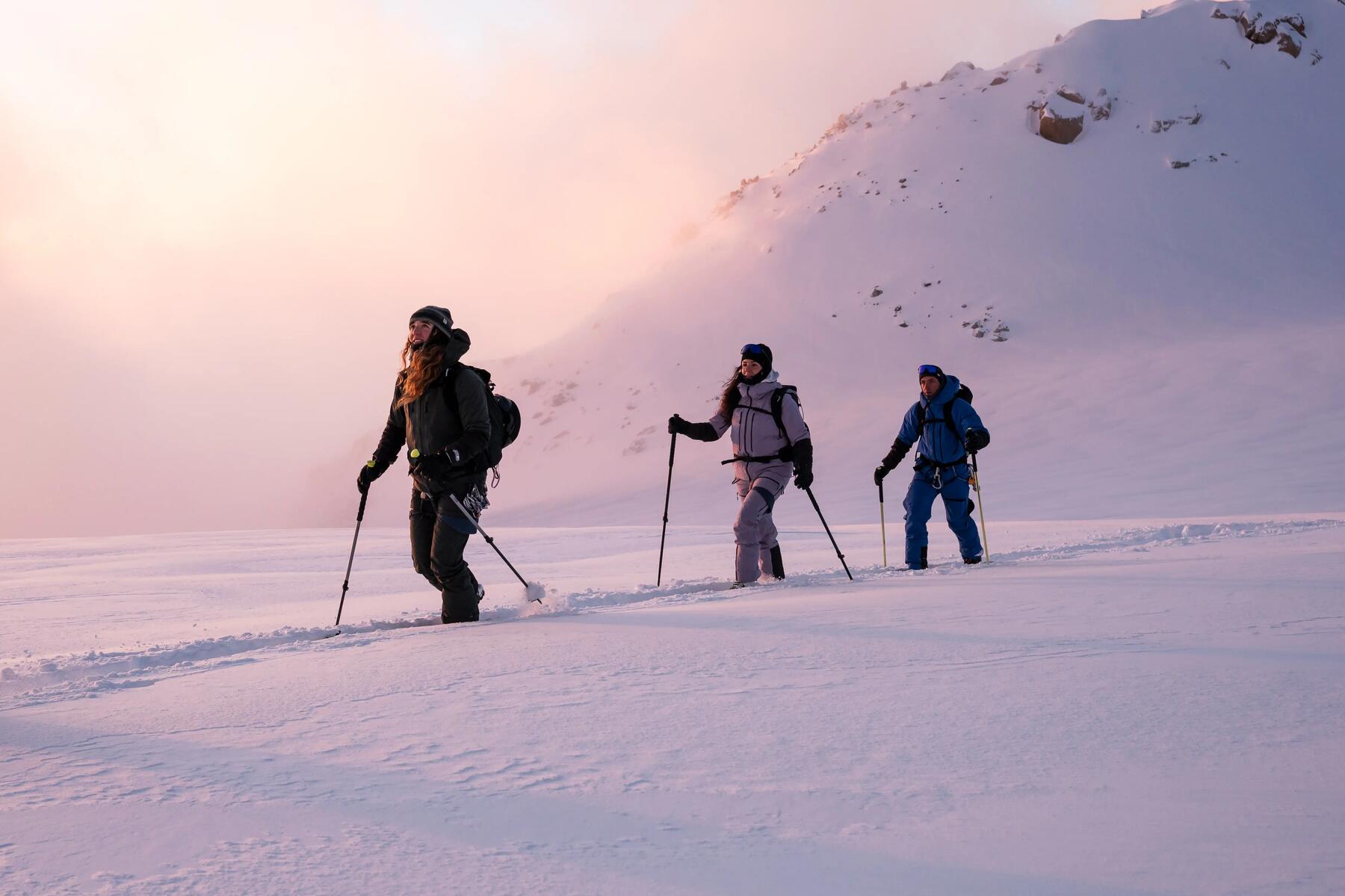 Drei Personen laufen auf Skiern und Skistöcken