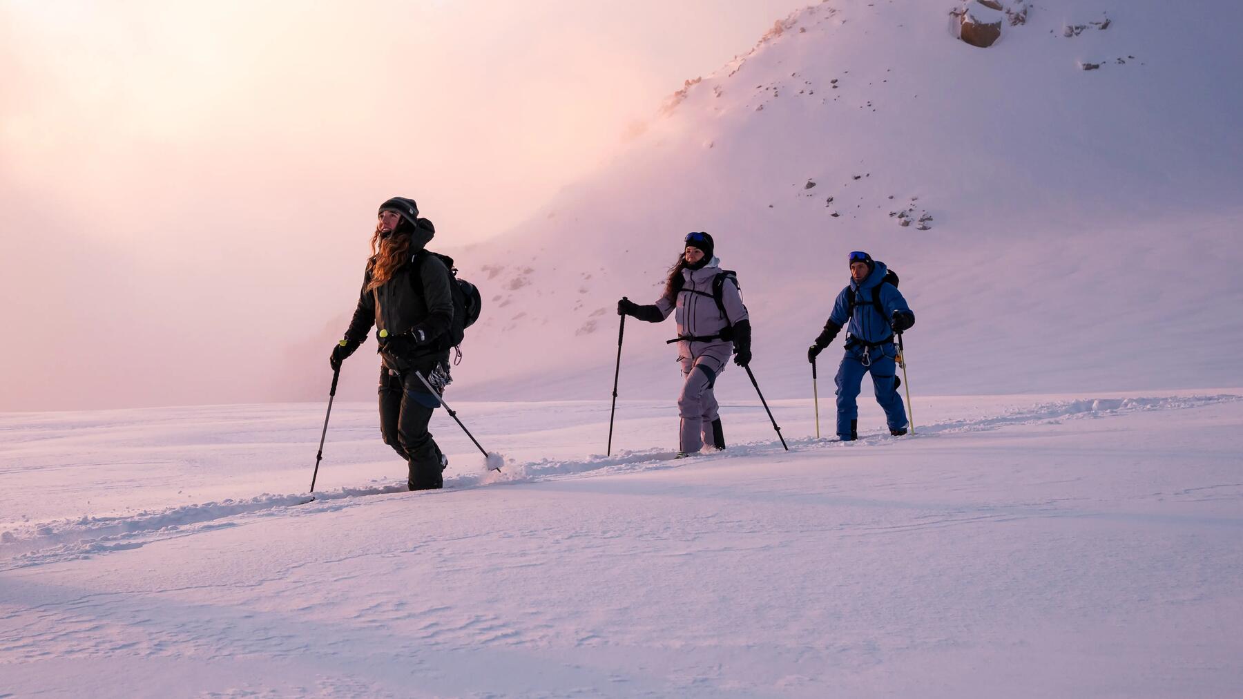 Skitourengeher im tiefen Pulverschnee bei Sonnenaufgang unterwegs