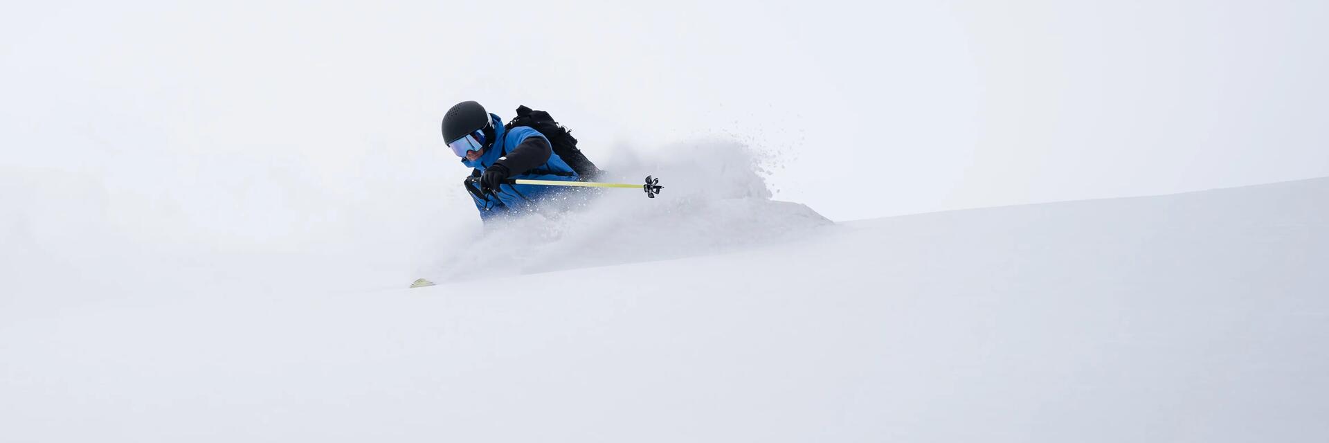 Mężczyzna szusujący na specjalnych nartach on piste na stoku