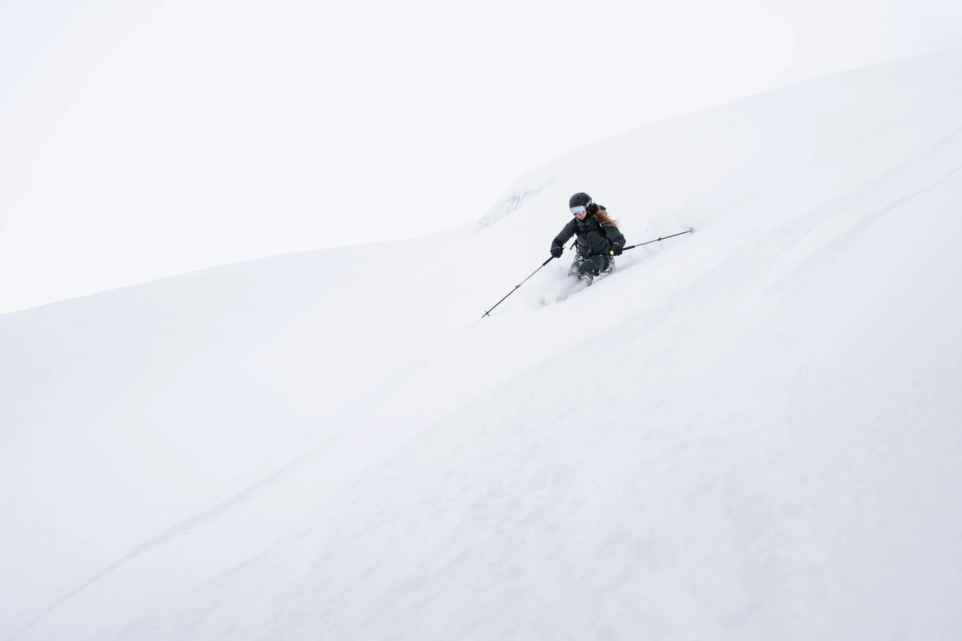 Kobieta szusująca na nartach on piste po stokach pełnych śniegu