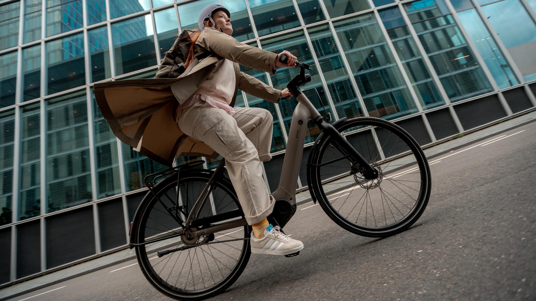 Frau in der Mittagspause unterwegs auf ihrem Fahrrad durch die Stadt.