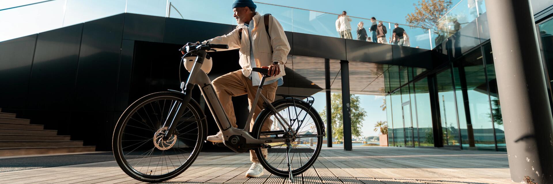 een man met een elektrishe fiets in de hand