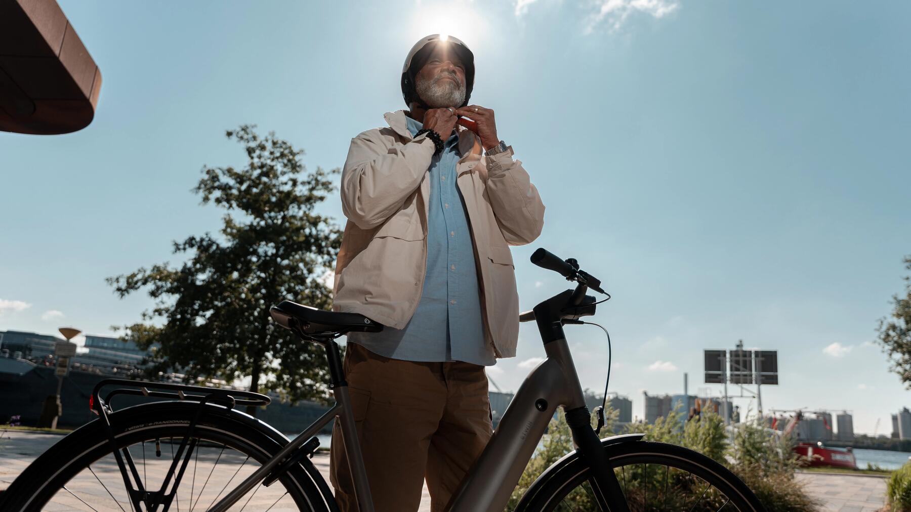 Homme avec un casque vélo et un vélo électrique