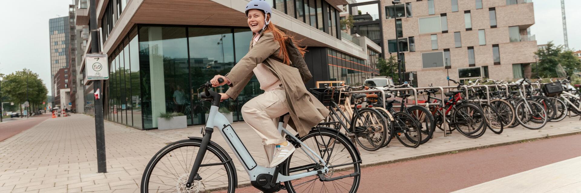 Kobieta jadąca na rowerze elektrycznym w mieście