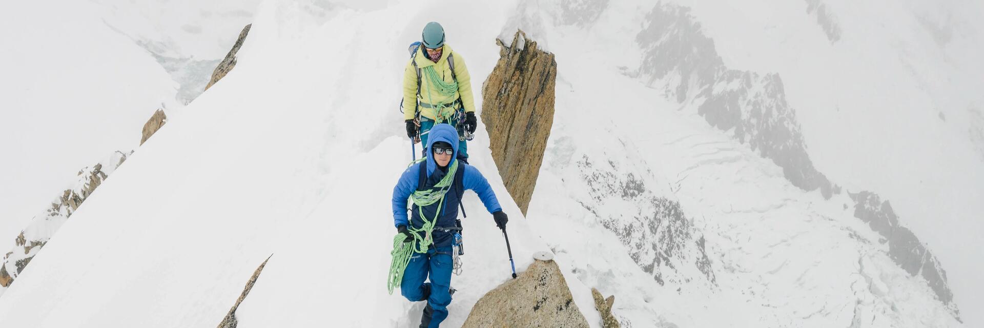 Mężczyźni wędrujący po górach ze sprzętem alpinistycznym chcąc dowiedzieć się ile kosztuje wejście na Mount Everest