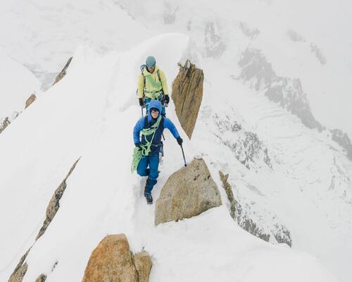 Mężczyźni wędrujący po górach ze sprzętem alpinistycznym chcąc dowiedzieć się ile kosztuje wejście na Mount Everest