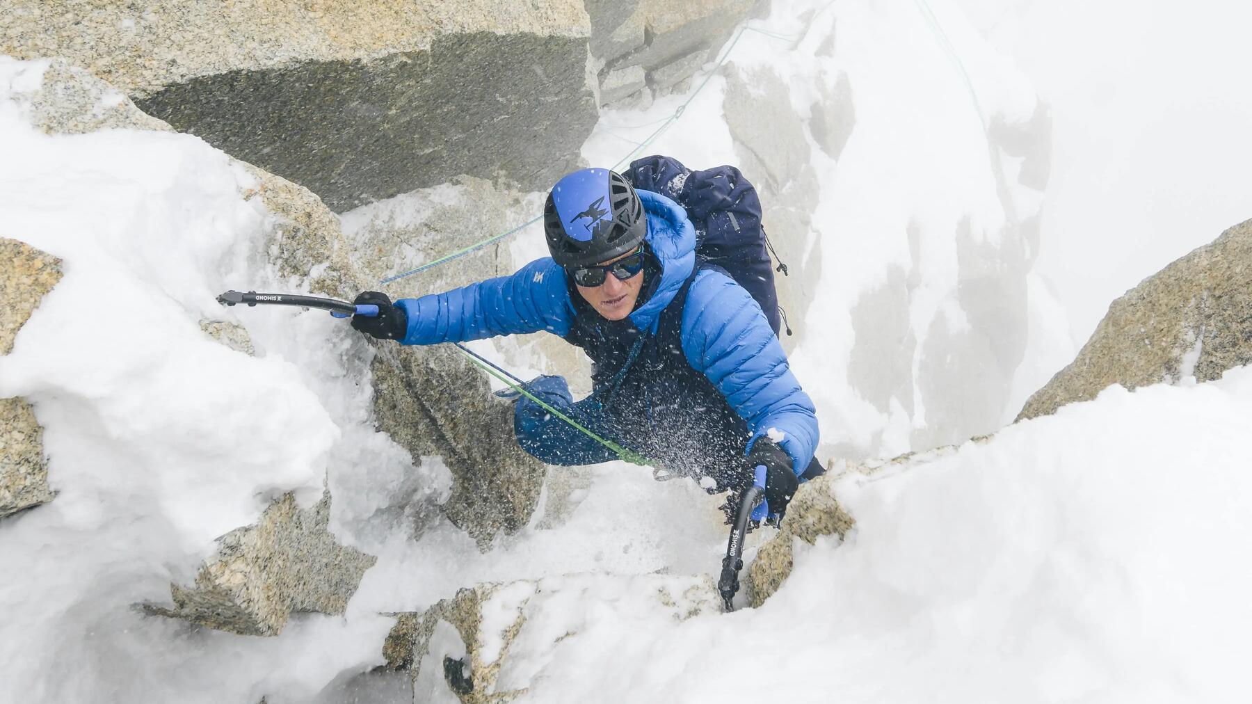Ein Mann nutzt Eispickel am Eisfall