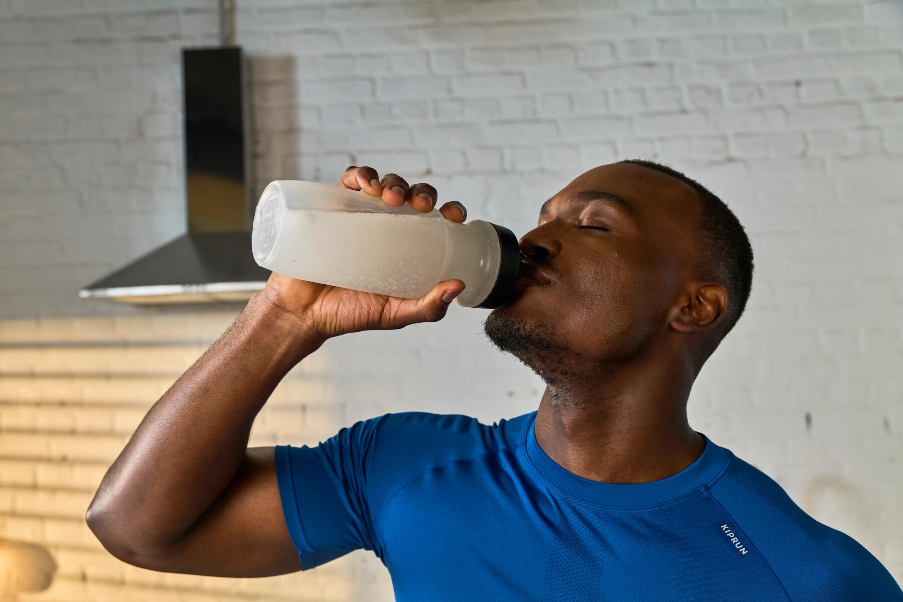 Een man drinkt een sportdrank