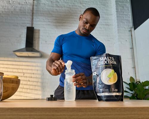 Mann bereitet sich einen Fitness-Shake, Nahrungsergänzung für Energie und Regenerationmit Maltodextrin zu, 
