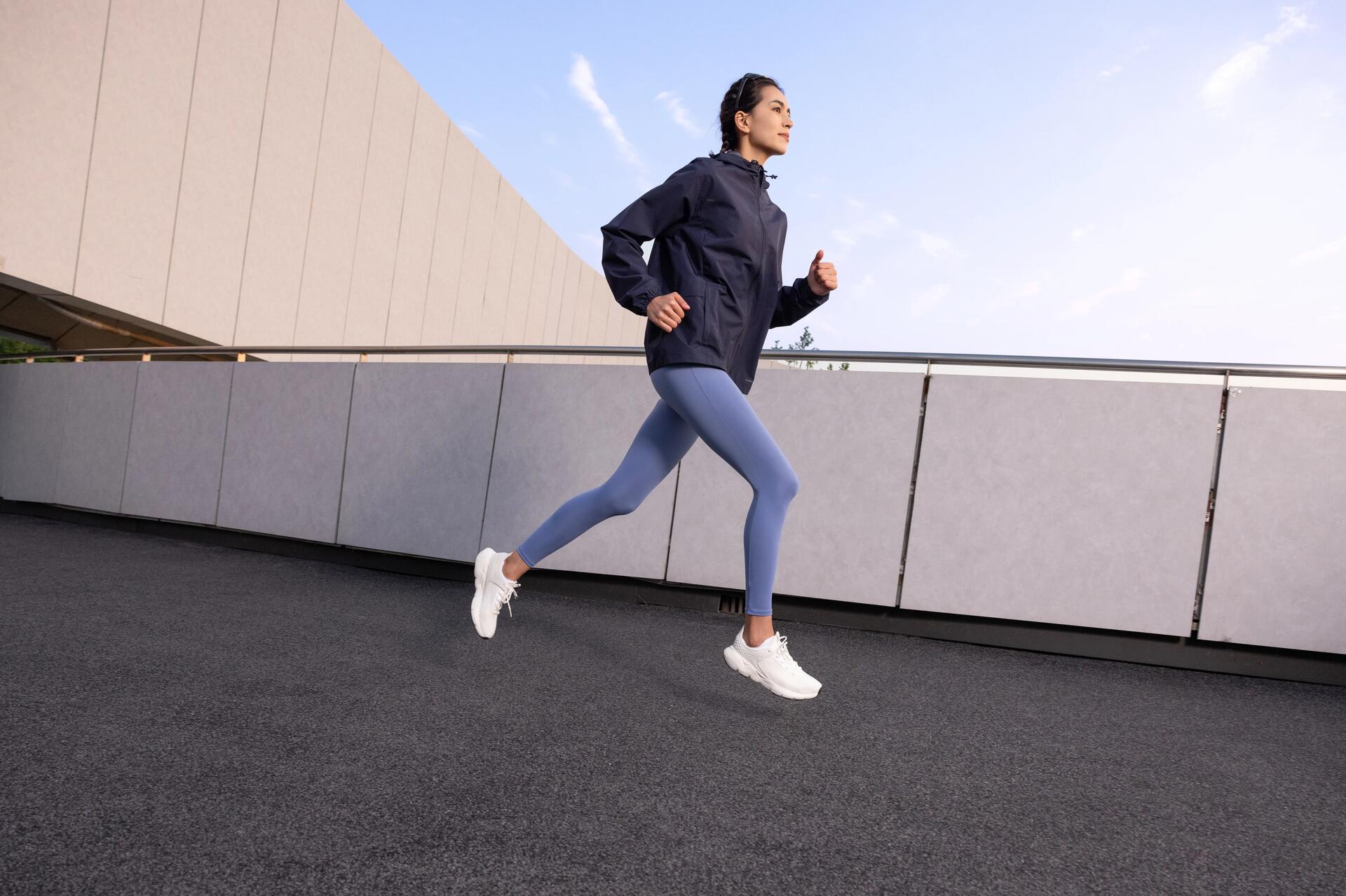 Kobieta w stroju sportowym biegająca po ścieżce dla pieszych na dworze