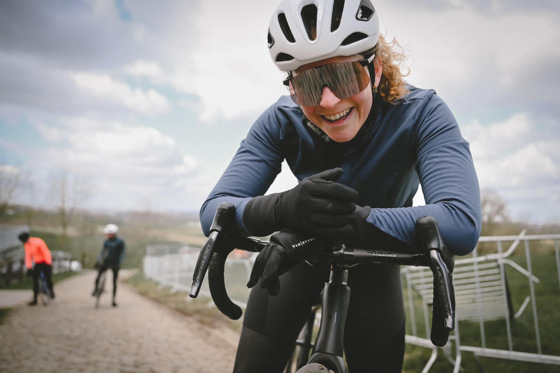 Cyclist holding their wrist and smiling at the camera