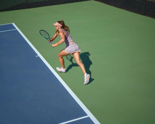 Kobieta w stroju sportowym na korcie trzymająca rakietę w ręku grająca w touchtennisa