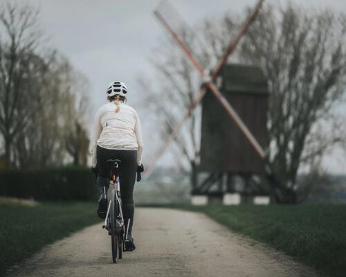 Kobieta w kasku rowerowym jadąca na rowerze z prawidłowo ustawionym siodełkiem