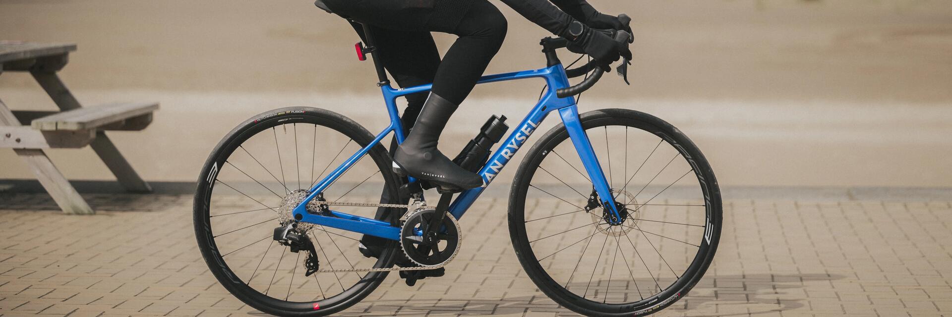 Osoba jadąca na rowerze w ochraniaczach na buty rowerowe