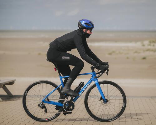 Osoba jadąca na rowerze w ochraniaczach na buty rowerowe