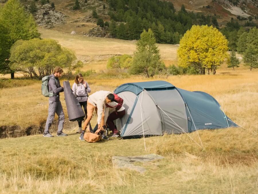 Three campers packing up their camping gear